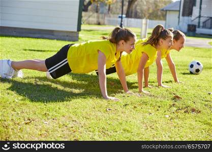 Friend girls teens push up push-ups workout ABS in a park turf grass
