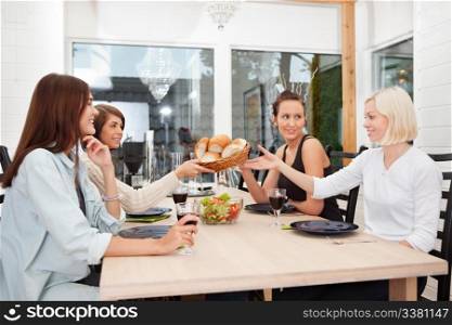Friend passing basket filled with buns at dining table