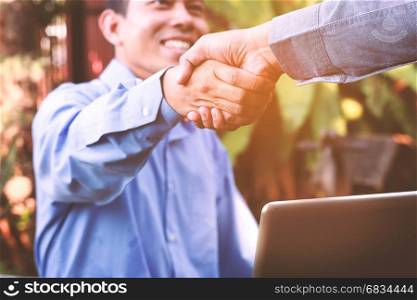 Friendly business man giving a handshake and smiling