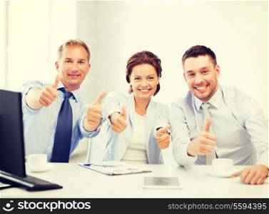 friendly business team showing thumbs up in office