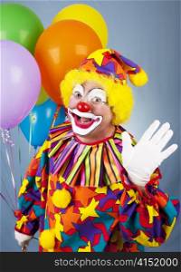 Friendly circus clown holding a bunch of balloons and waving hello.