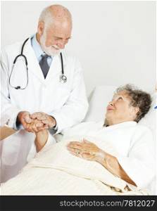 Friendly doctor comforting a senior hospital patient.
