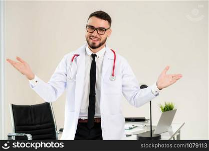 Friendly doctor portrait at office desk in the hospital looking at camera. Medical and healthcare concept.