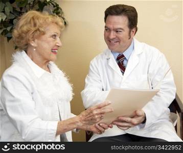 Friendly doctor sitting beside his patient, going over her chart.