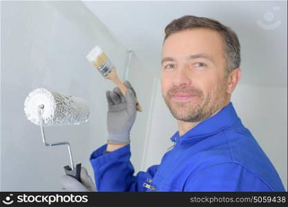 friendly handsome painter painting a wall in a house
