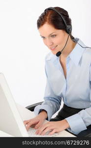 Friendly help desk woman at call center sitting behind computer