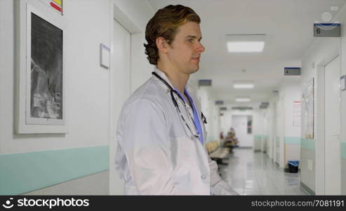 Friendly male doctor turns to camera in a facility