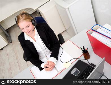 Friendly receptionist on the phone wearing a headset and microphone