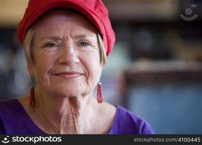 Friendly senior woman wearing a red hat