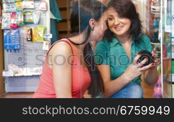 Friendly shop representative offers goods to a buyer in the cosmetics department