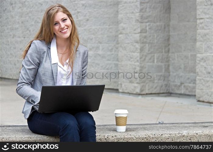 Friendly woman working on laptop outdoors