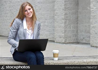Friendly woman working on laptop outdoors