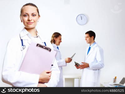 Friendly young female doctor in uniform in medical office