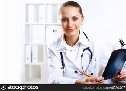 Friendly young female doctor in uniform in medical office