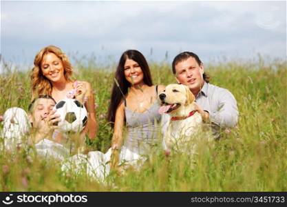 friends and dog in green grass field