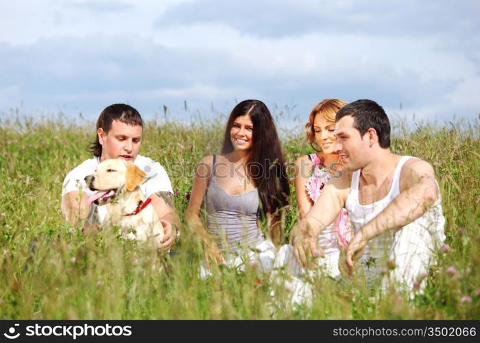 friends and dog in green grass field