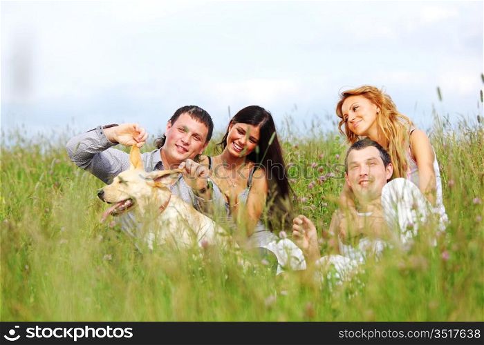 friends and dog in green grass field