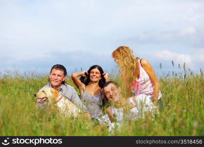 friends and dog in green grass field