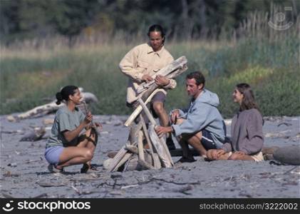 Friends Building A Campfire On The Beach