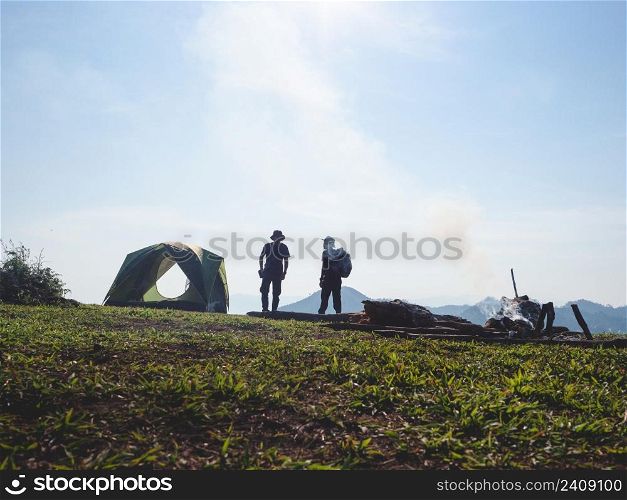 Friends camping on mountain peak.