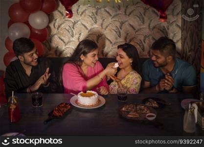 Friends celebrating birthday of their friend at restaurant 