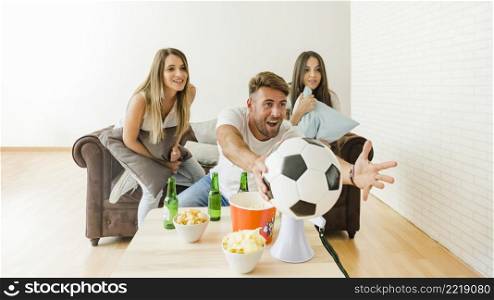 friends cheering watching football home