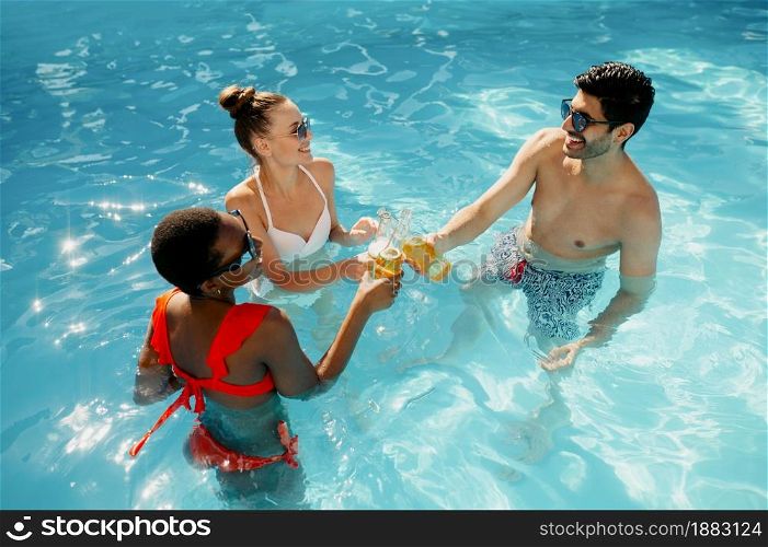 Friends drink beverages in the pool, top view. Happy people having fun on summer vacations, holiday party at the poolside outdoors. Friends drink beverages in the pool, top view