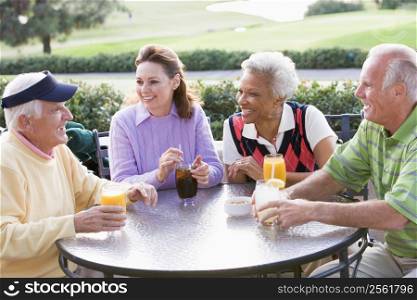 Friends Enjoying A Beverage By A Golf Course