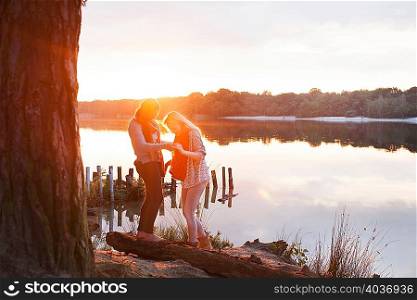 Friends enjoying lake at sunset