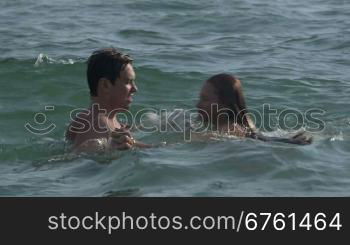 Friends enjoying summer beach vacation playing in water