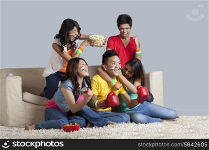 Friends enjoying together while watching a boxing match at home