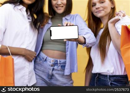 friends holding shopping bags blank phone