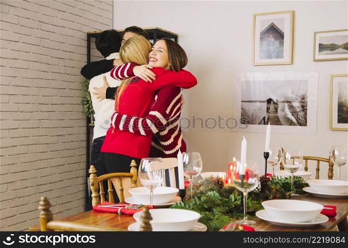 friends hugging before christmas dinner