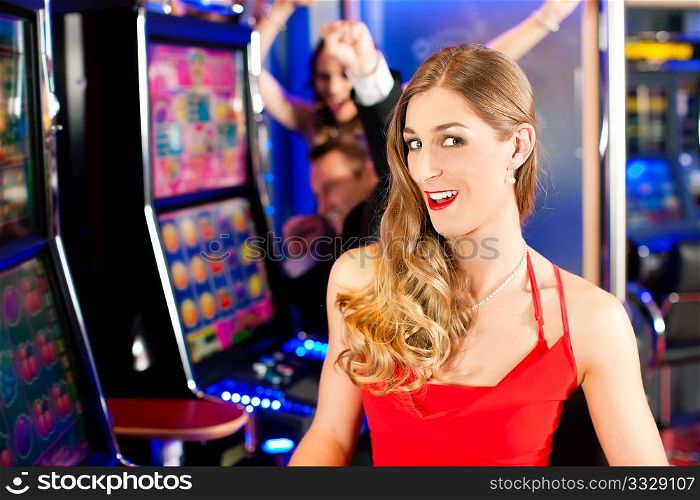 Friends in Casino on a slot machine; a woman is looking into the camera