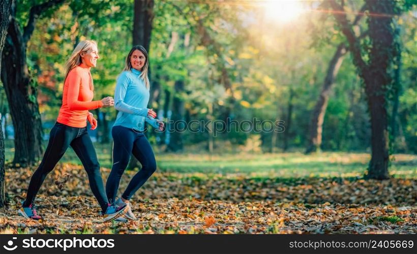 Friends Jogging outdoors, Public Park in Autumn. . Friends Jogging Outdoors