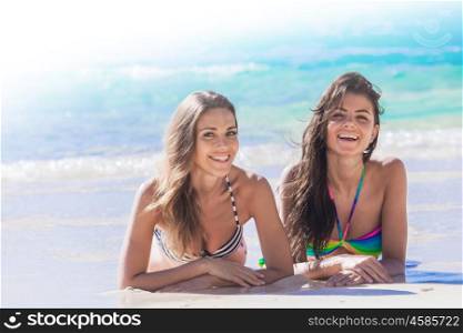 Friends laying on sand. Two female friends laying on the sand of tropical beach