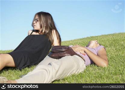 Friends lying on grass in sun