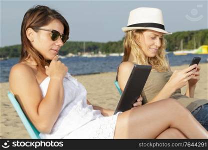 friends on vacation with tablet and smartphone