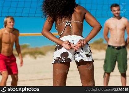 Friends playing beach volleyball, one girl giving the strategy to the player in the same team