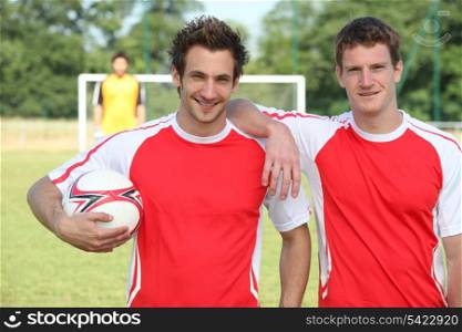 friends playing football posing together