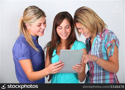 Friends playing with electronic pad on white background
