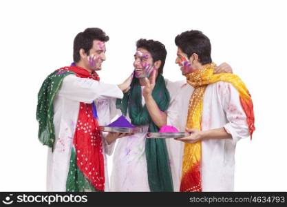 Friends putting holi colours on each other