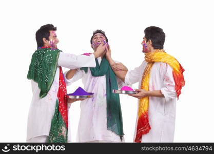 Friends putting holi colours on each other