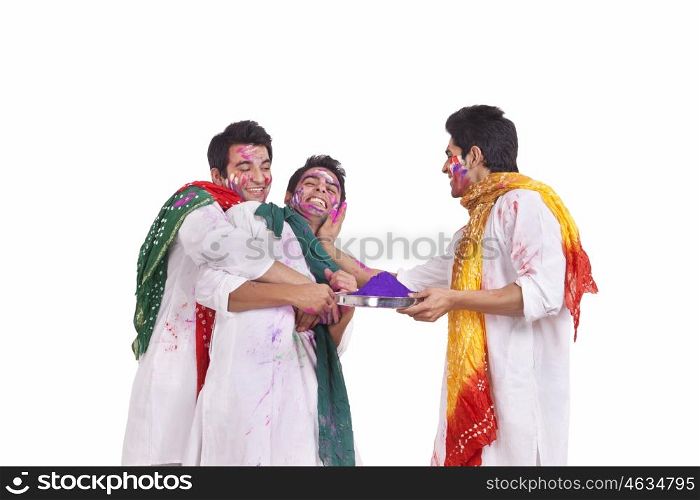 Friends putting holi colours on each other