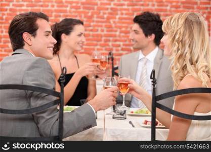 Friends raising their glasses in a toast at a restaurant