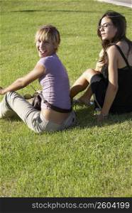 Friends sitting on grass in the sun