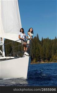 Friends Standing on Bow of Sailboat