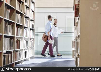 Friends talking while walking in university library