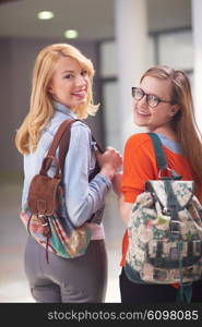 friends together at school, two student girls with backpack and tablet on university