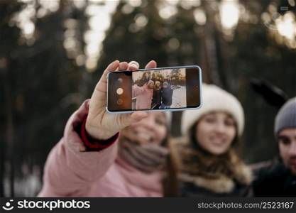 friends together taking selfie outdoors winter